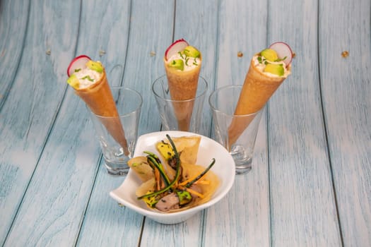 Brick with marinated red tuna, soy sauce, nuoc mam, ginger, black sesame, avocado, carrot slices, courgette and cornet with pieces of red tone. High quality photo