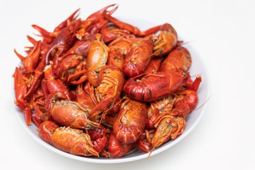 Red boiled crayfish with lemon on the plate isolated on a white background.