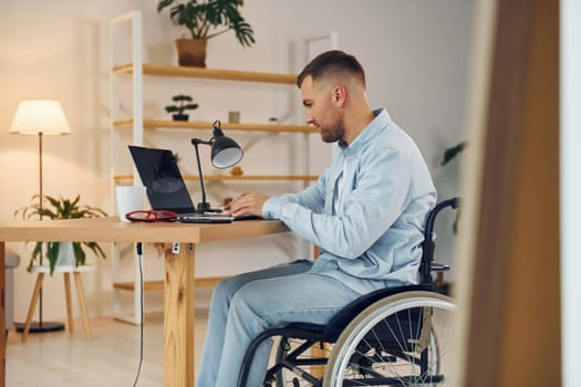 Business worker. Disabled man in wheelchair is at home.