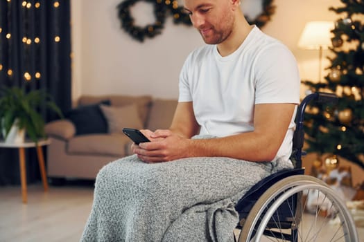 New year is coming. Disabled man in wheelchair is at home.