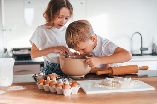 Preparing Christmas cookies. Little boy and girl on the kitchen.