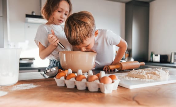 Brother and sister. Little boy and girl preparing Christmas cookies on the kitchen.