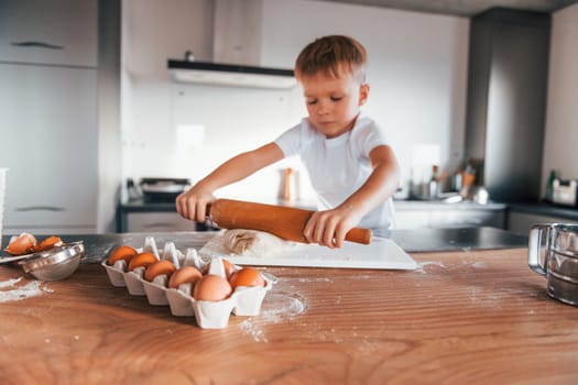 Little boy preparing Christmas cookies on the kitchen.