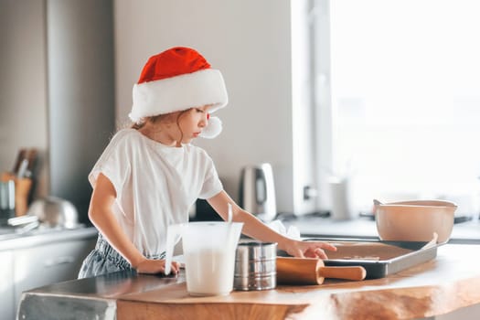 Little girl preparing Christmas cookies on the kitchen.