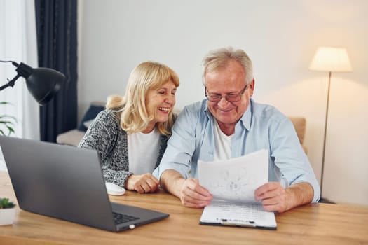 Using laptop. Senior man and woman is together at home.