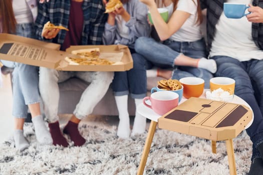 Pizza and cookies. Group of friends have party indoors together.