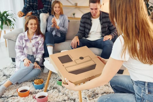 Sitting on the sofa. Group of friends have party indoors together.