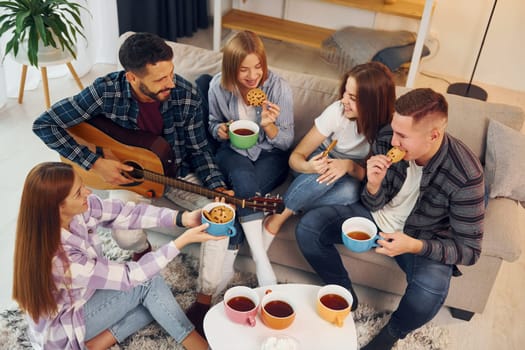 In domestic room. Group of friends have party indoors together.