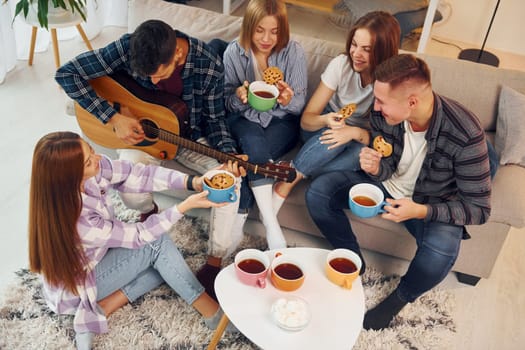 In domestic room. Group of friends have party indoors together.