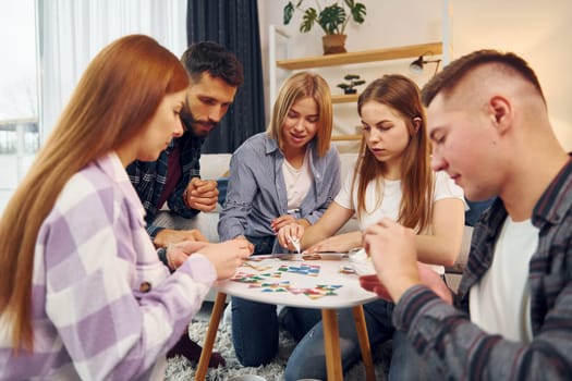 In domestic room. Group of friends have party indoors together.