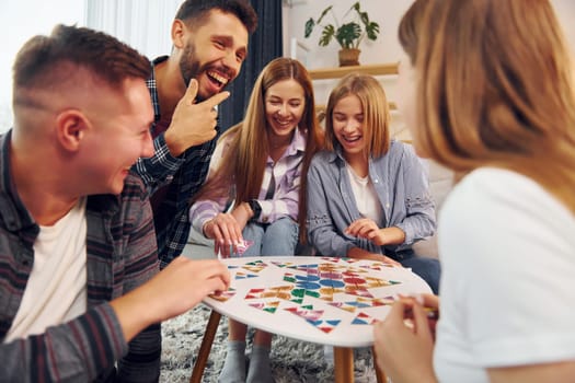 Playing smart game. Group of friends have party indoors together.