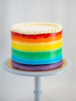 pastry chef working on a frosted cup cake with lgbt rainbow colours for wedding union party celebration. Birthday cupcake. Rainbow paper cup liners. Happy Birthday. Celebration Holidays. LGBT pride.