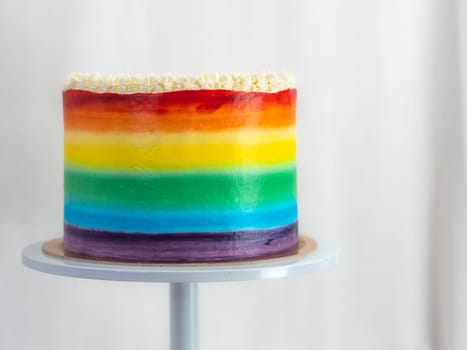 pastry chef working on a frosted cup cake with lgbt rainbow colours for wedding union party celebration. Birthday cupcake. Rainbow paper cup liners. Happy Birthday. Celebration Holidays. LGBT pride.