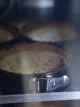 chef pastry baker cooking a bunch key lime pies in the oven