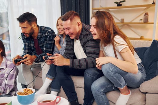 Free time entertainment. Group of friends have party indoors together.