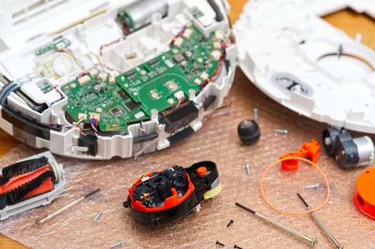 Serviceman, Repairman, maintenance on robotic vacuum cleaner. Repairing robot cleaner. Electronics repair concept