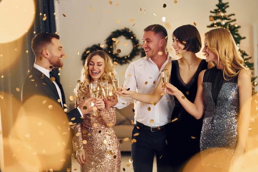 X-mas time. Group of people have a new year party indoors together.