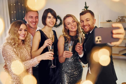 Positive emotions. Group of people have a new year party indoors together.
