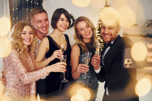 Positive emotions. Group of people have a new year party indoors together.