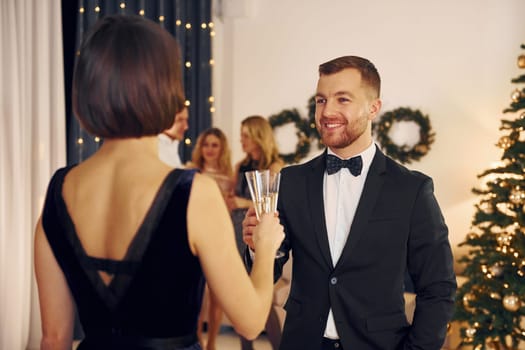 Having conversation. Group of people have a new year party indoors together.