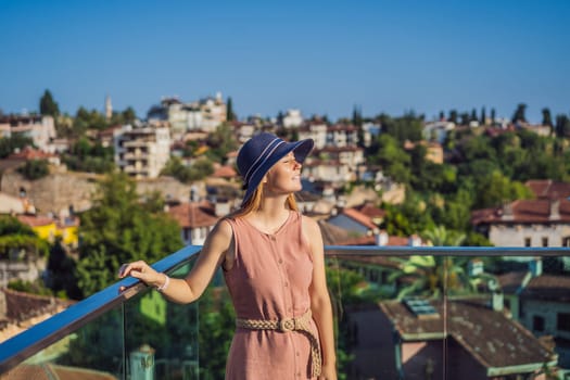 Woman tourist in Old town Kaleici in Antalya. Turkiye. Panoramic view of Antalya Old Town port, Taurus mountains and Mediterrranean Sea, Turkey.