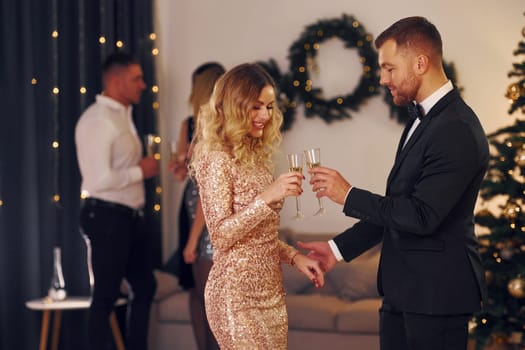 Group of people have a new year party indoors together.