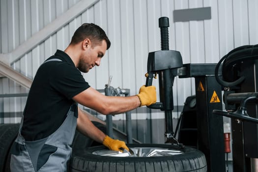 Strong hands. Man in uniform is working in the auto service.