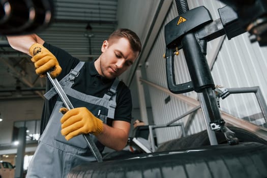 Employee at work. Man in uniform is in the auto service.