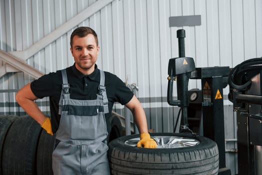 Employee at work. Man in uniform is in the auto service.