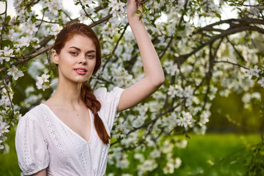 Beautiful young woman. model in white dress stands in white flowers. Horizontal photo. copy space.High quality photo