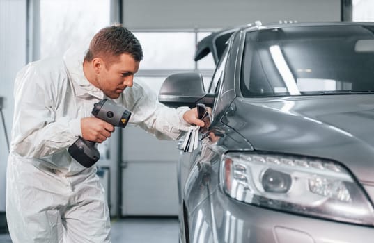 Professional worker. Man in uniform is in the auto service.