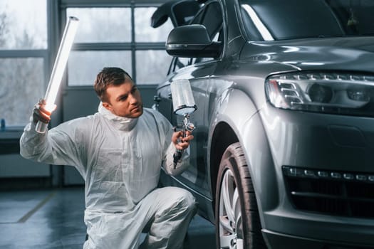 Professional worker. Man in uniform is in the auto service.