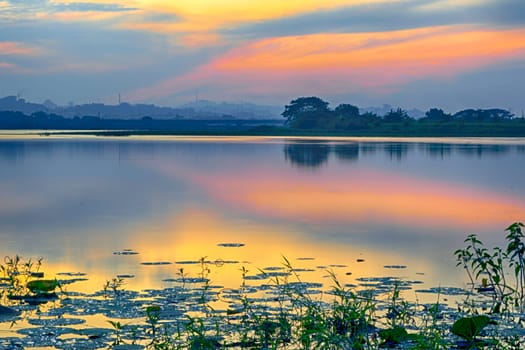 Beautiful view of Waduk Bunder or Water Dam Bunder in Gresik, East Java, Indonesia during sunrise and cloudy wheater.