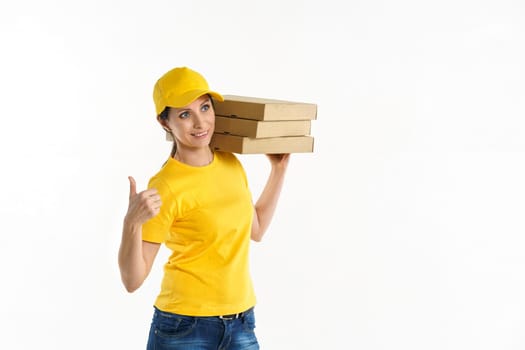 A woman of Caucasian appearance, a brunette, a delivery woman in a t-shirt uniform and a yellow baseball cap holding boxes of pizza in her hands on a white background