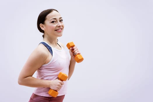 happy caucasian woman in sportswear is engaged with dumbbells. Healthy lifestyle concept