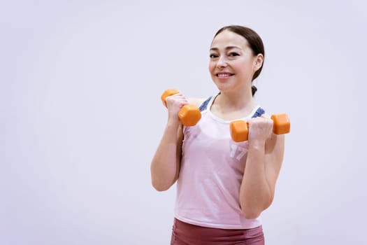 happy caucasian woman in sportswear is engaged with dumbbells. Healthy lifestyle concept