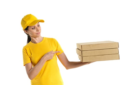 A pizza delivery woman of Caucasian appearance in a yellow uniform, holding cardboard boxes in her hands on a white background.