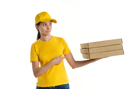 A woman of Caucasian appearance, a brunette, a delivery woman in a t-shirt uniform and a yellow baseball cap holding boxes of pizza in her hands on a white background