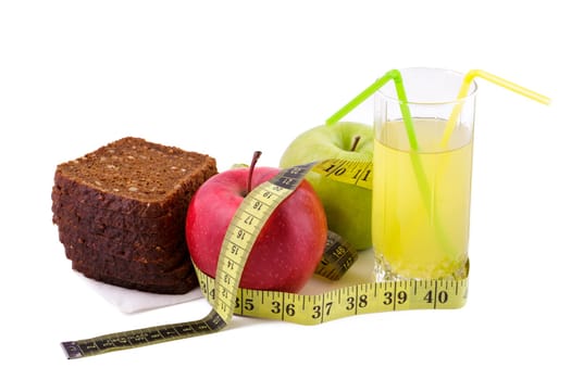 Rye bread with green and red apples and juice in a glass on a white plate with a yellow measuring tape. Diet and healthy food concept