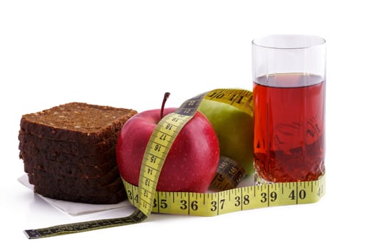 Rye bread with green and red apples and juice in a glass on a white plate with a yellow measuring tape. Diet and healthy food concept