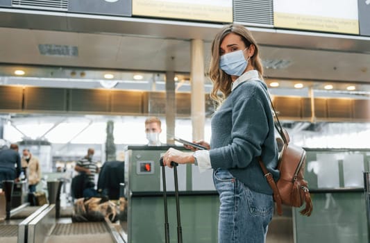 Receiving help from worker. Young female tourist is in the airport at daytime.