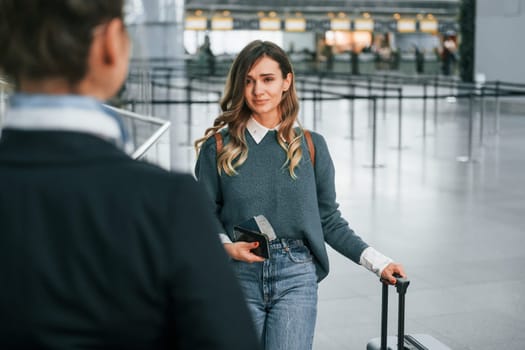 Pass procedure. Young female tourist is in the airport at daytime.