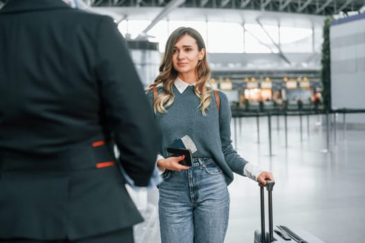 Pass procedure. Young female tourist is in the airport at daytime.