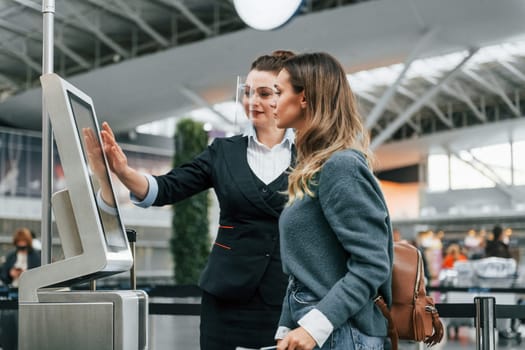 Using terminal. Young female tourist is in the airport at daytime.