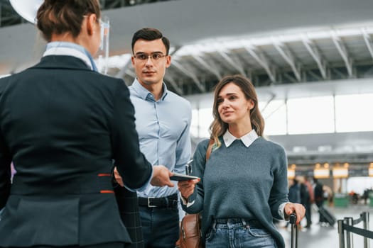 Checking documents at the entrance. Young couple is in the airport together.