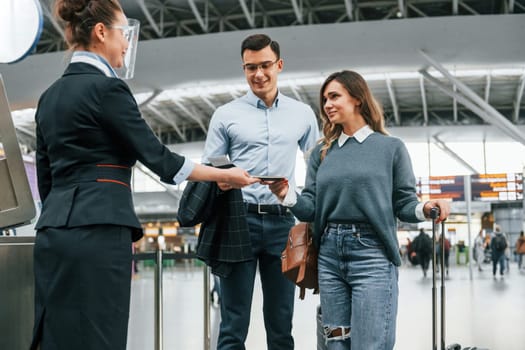 Checking documents at the entrance. Young couple is in the airport together.