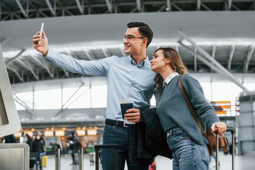 Making selfie. Young couple is in the airport together.