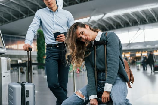 Woman is tired. Young couple is in the airport together.