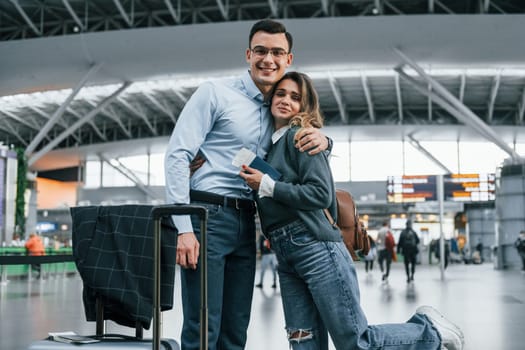 Embracing each other. Young couple is in the airport together.