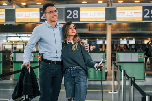 Embracing each other. Young couple is in the airport together.